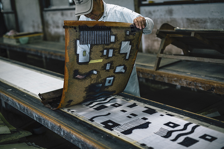 色の数だけ用意された型紙の位置をあわせながら染めていく。 Photo Kosuke Tamura