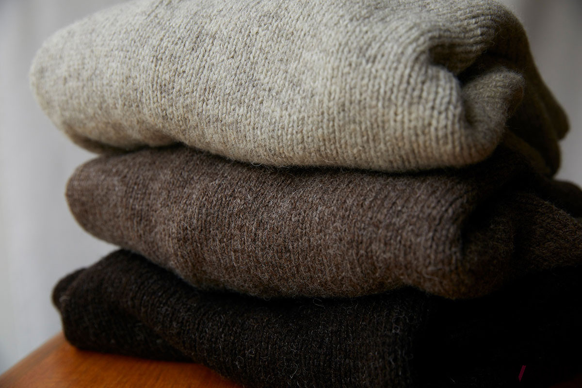 手横編み機を使用したイギリスの伝統的なハンドフレーム製法で編み上げており、職人の技術と経験が生み出す、やわらかな風合いを感じられる