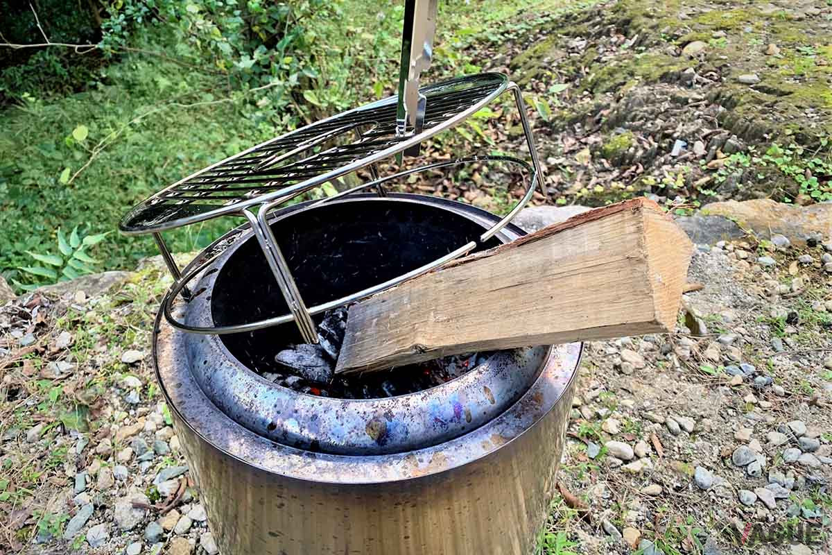 五徳中央の穴から薪を投入するが、穴には入らない極太の薪は脇から。このときも付属のハンドルが活躍