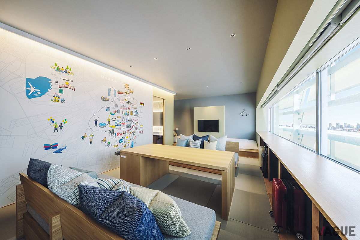 客室「いどばたスイート」のリビングには、大阪の代表的な観光スポットが描かれた“OSAKAボード”と大きなテーブル、ソファを配置。最大6名まで宿泊できる