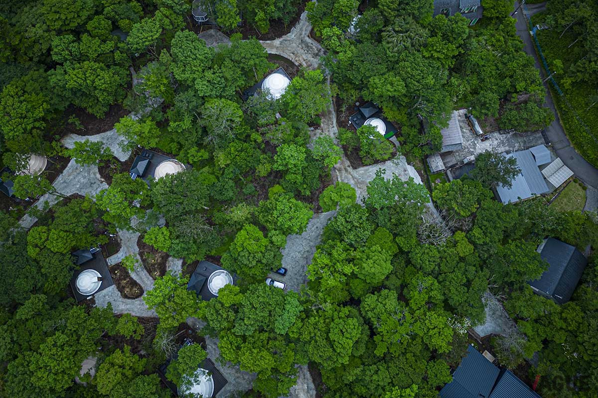 標高1000mを超す十里木高原に誕生した「MOSS十里木キャンプリゾート」は、ドーム型グランピングテントやトレーラーハウスを配した広大な敷地に建つ