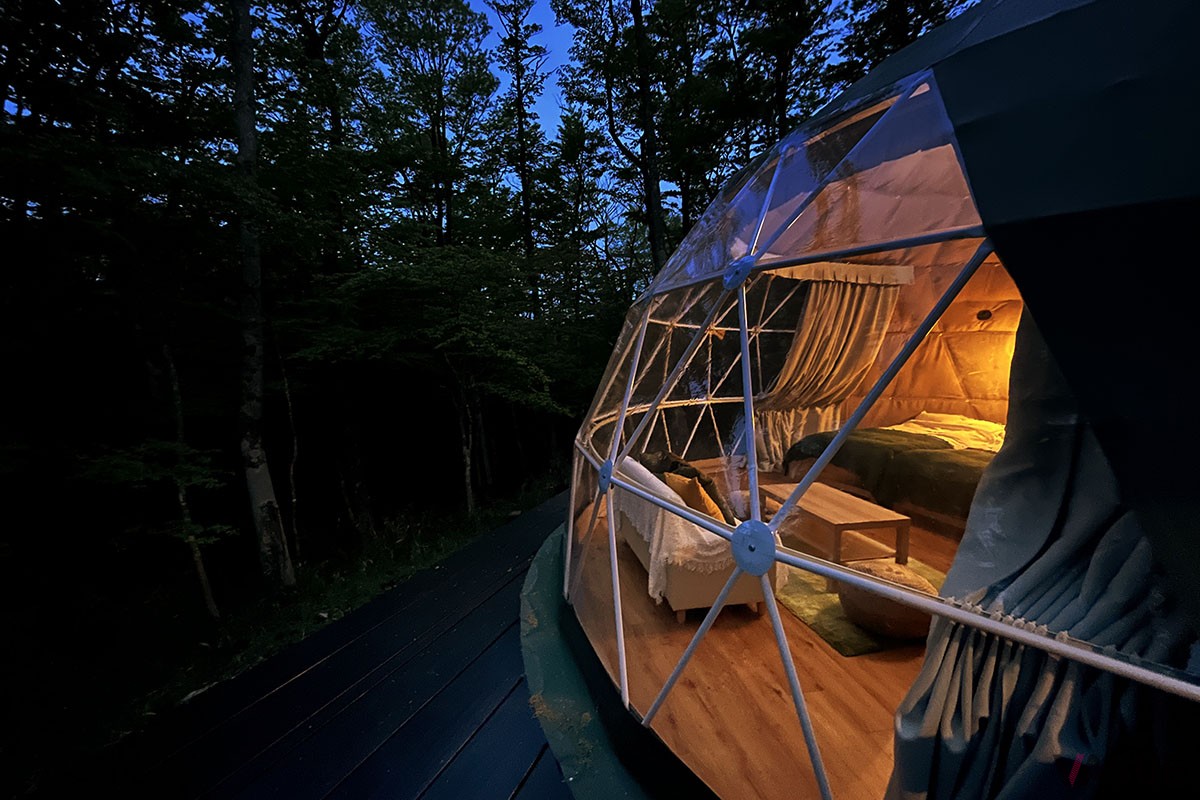 標高1000mを超す十里木高原に誕生した「MOSS十里木キャンプリゾート」は、ドーム型グランピングテントやトレーラーハウスを配した広大な敷地に建つ