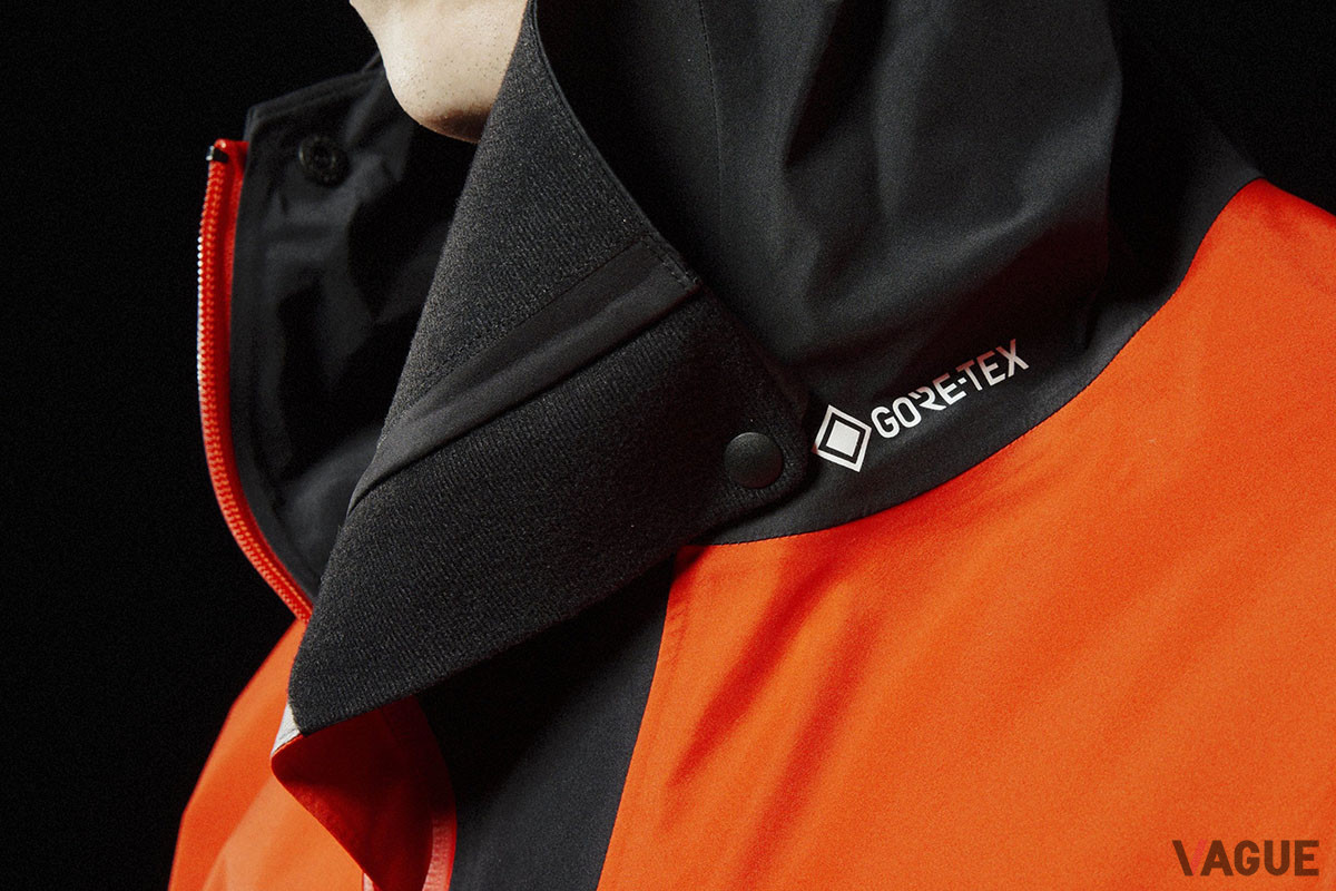 ジッパーを開けた際に、ばたつく襟元を固定できるドットボタンが備わる