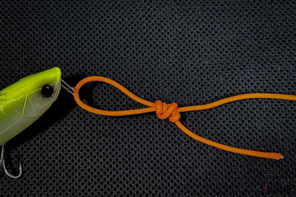 【ユニノット：STEP4】支線を引いて結び目が小さくなったら、本線を引いて結び目をルアーに近づけながら絞り込みます。このとき、摩擦熱を抑えるためつばで少し湿らせます