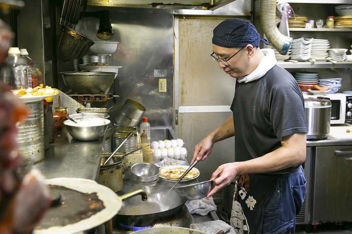 店主の野木さん。酔來丼用の目玉焼きを次々と揚げ焼きにしていく
