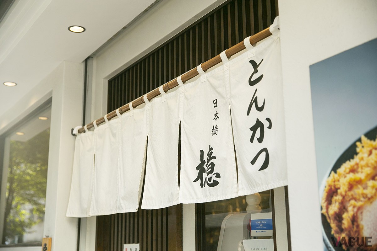 中央通りを一歩入ったところにある。白いのれんと大きなトンカツの写真が目印