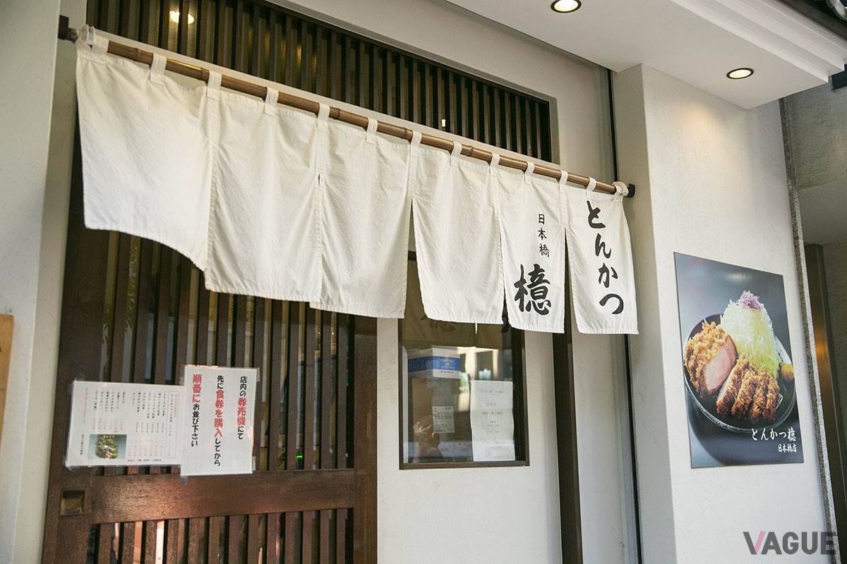 中央通りを一歩入ったところにある。白いのれんと大きなトンカツの写真が目印