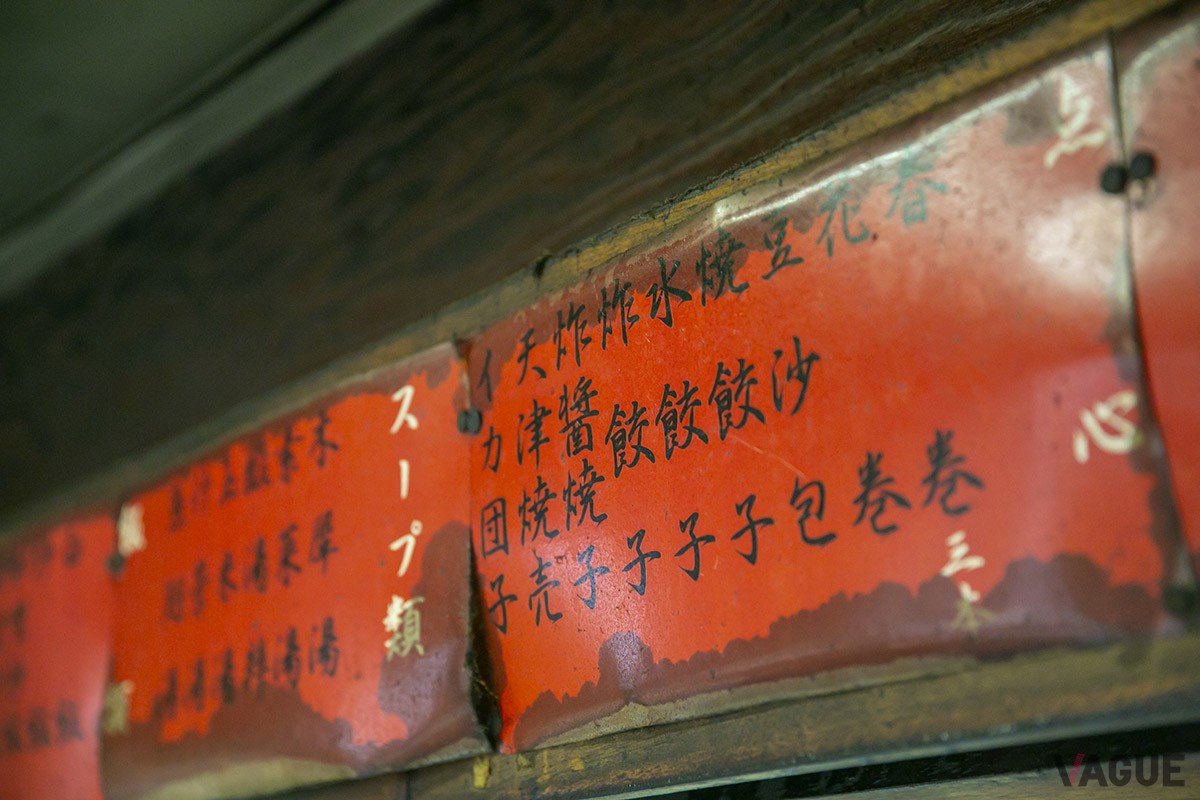 壁に貼られたメニュー。赤い紙に書かれているのも中華料理店らしい