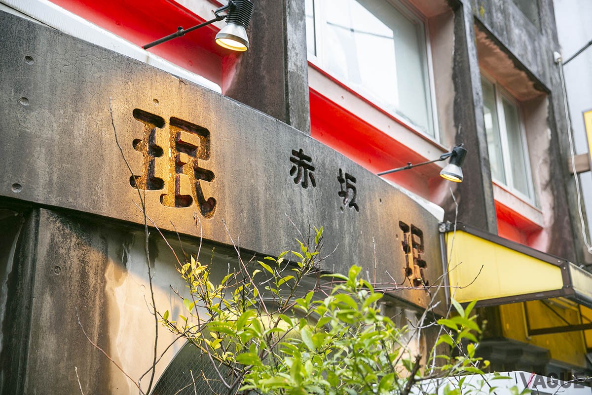 赤坂の住宅街の小道に建つ。店の歴史を感じる黄色い看板