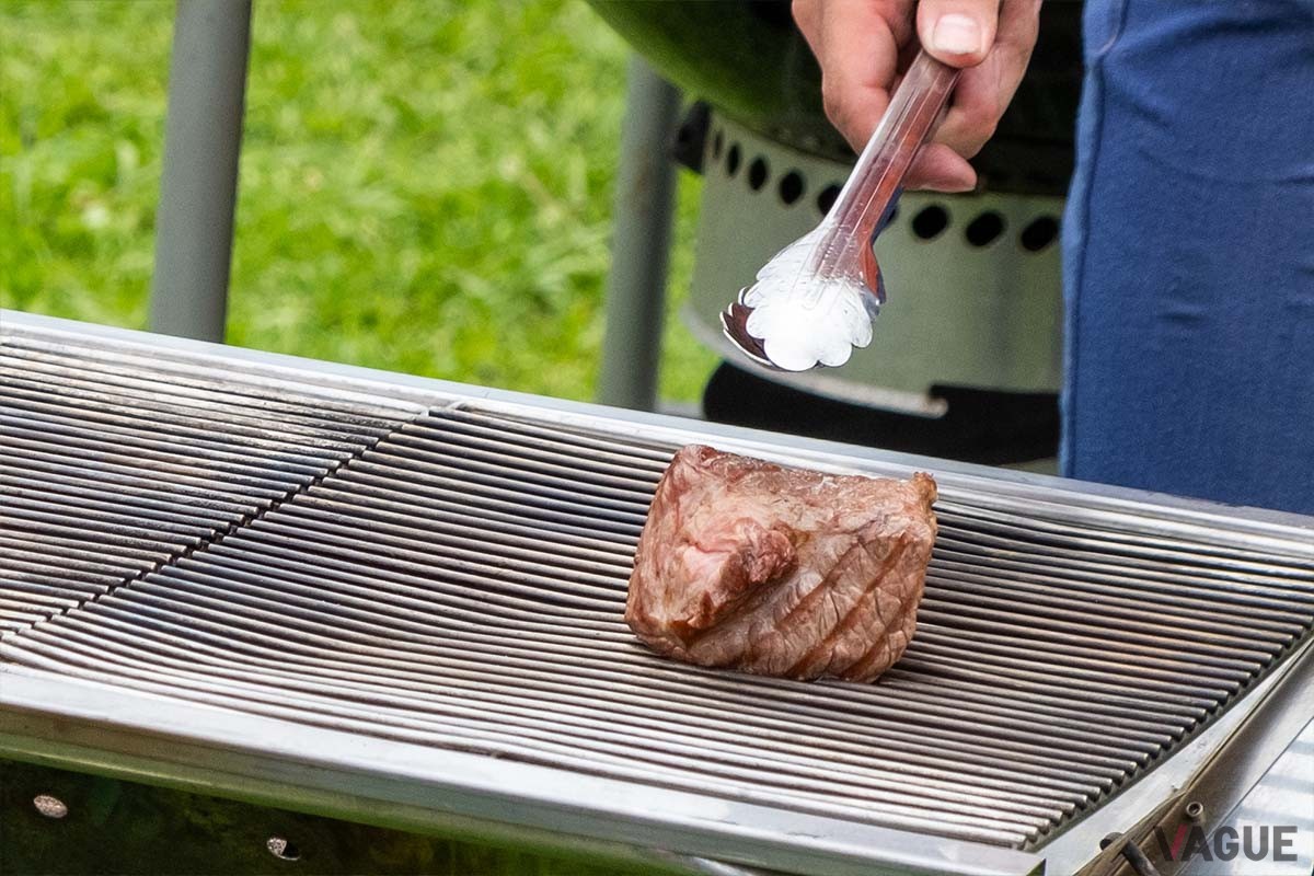 トングで肉を押して固さで焼き加減をチェック