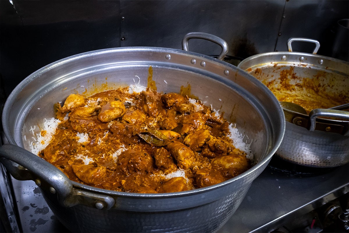 半茹でにした米の上にカレーソースを重ねます。カラチの空では、一回で約40人分ものビリヤニが作れる大きな鍋を使い、多い日には一日に5回も仕込むのだとか