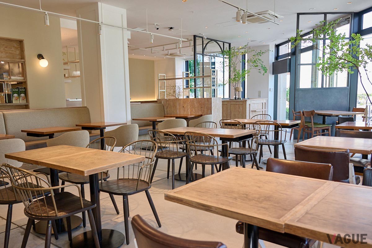 落ち着いた雰囲気のテーブルとチェアが並ぶ店内。季節の枝ものがセンスよく配置される