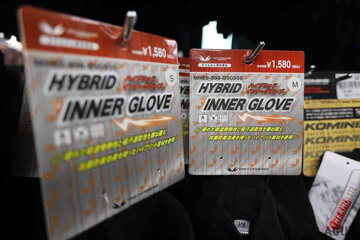 バイク用品店で陳列されている多数のインナーグローブ。電熱グローブと並び人気の商品だ