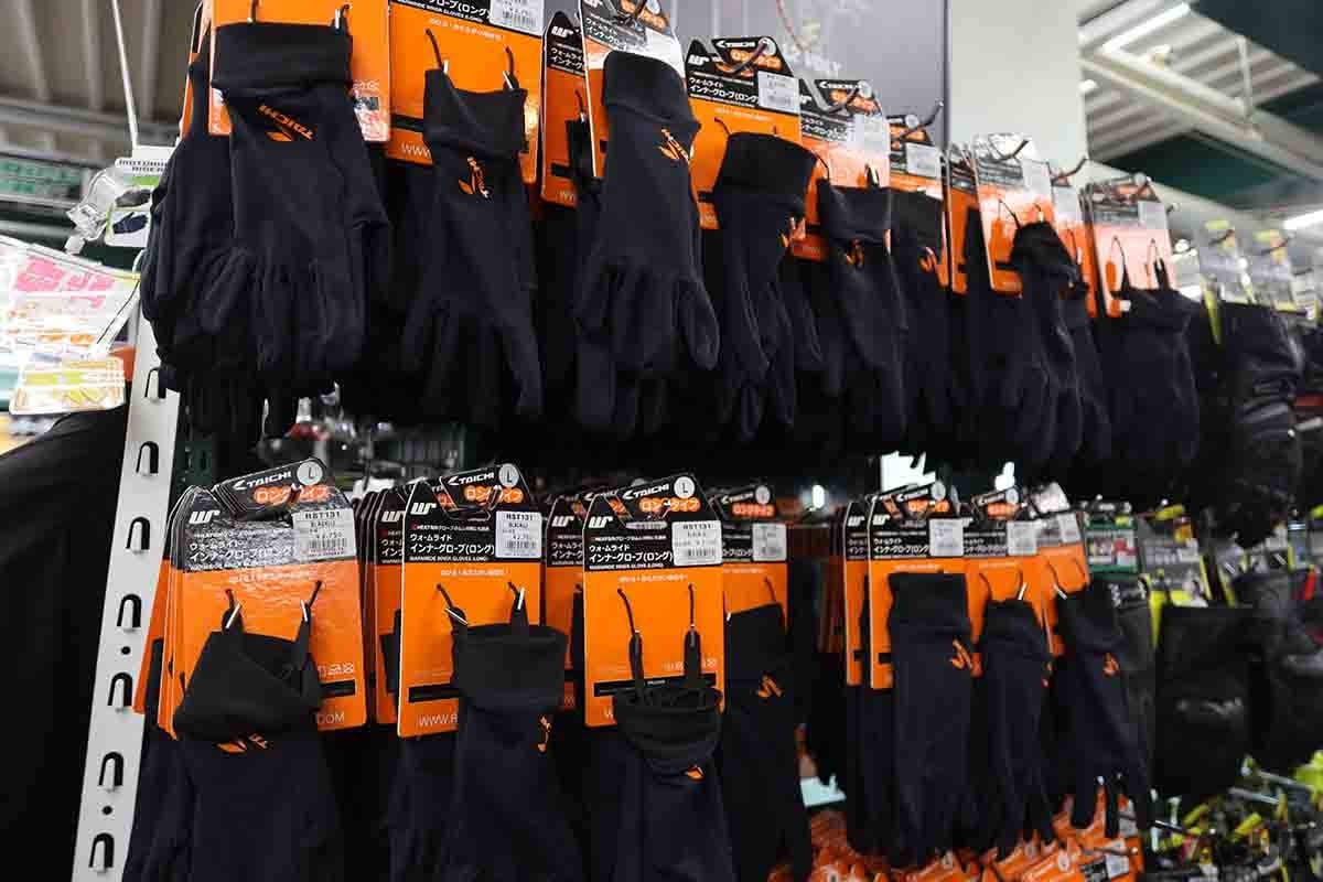 バイク用品店で陳列されている多数のインナーグローブ。電熱グローブと並び人気の商品だ