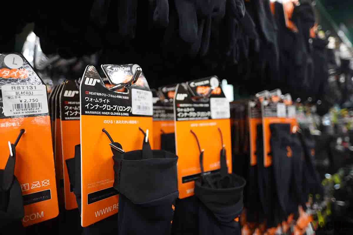 バイク用品店で陳列されている多数のインナーグローブ。電熱グローブと並び人気の商品だ