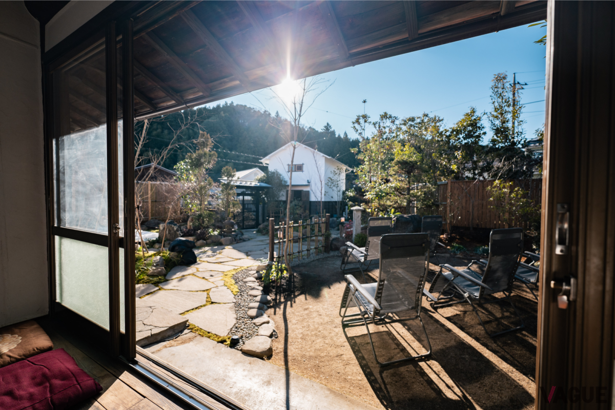 日本庭園やサウナの蔵、そしてその背後にある青梅の山々を眺める