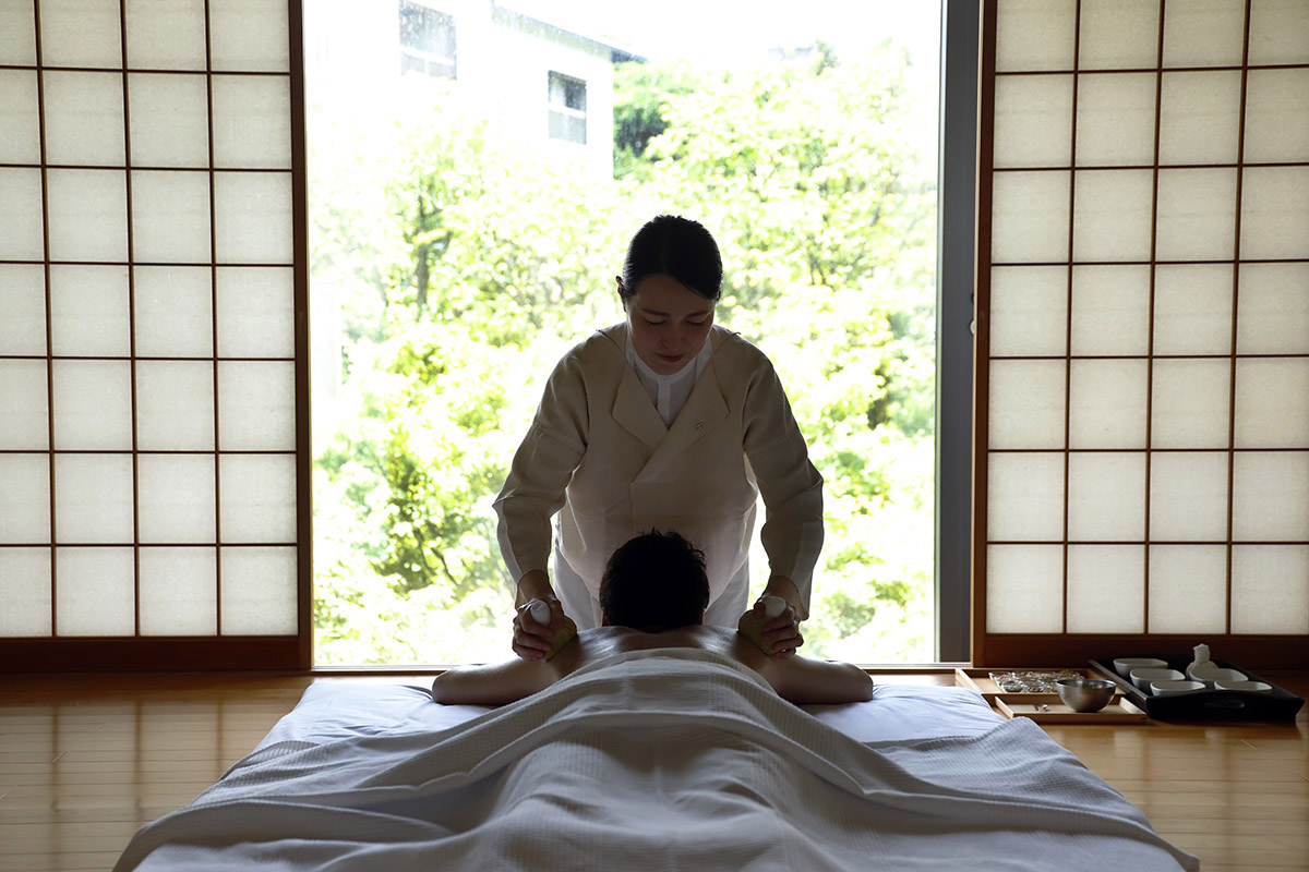 「べにや無何有」のスパ「円庭施術院」で“薬師山トリートメント”の施術を受ける小原さん