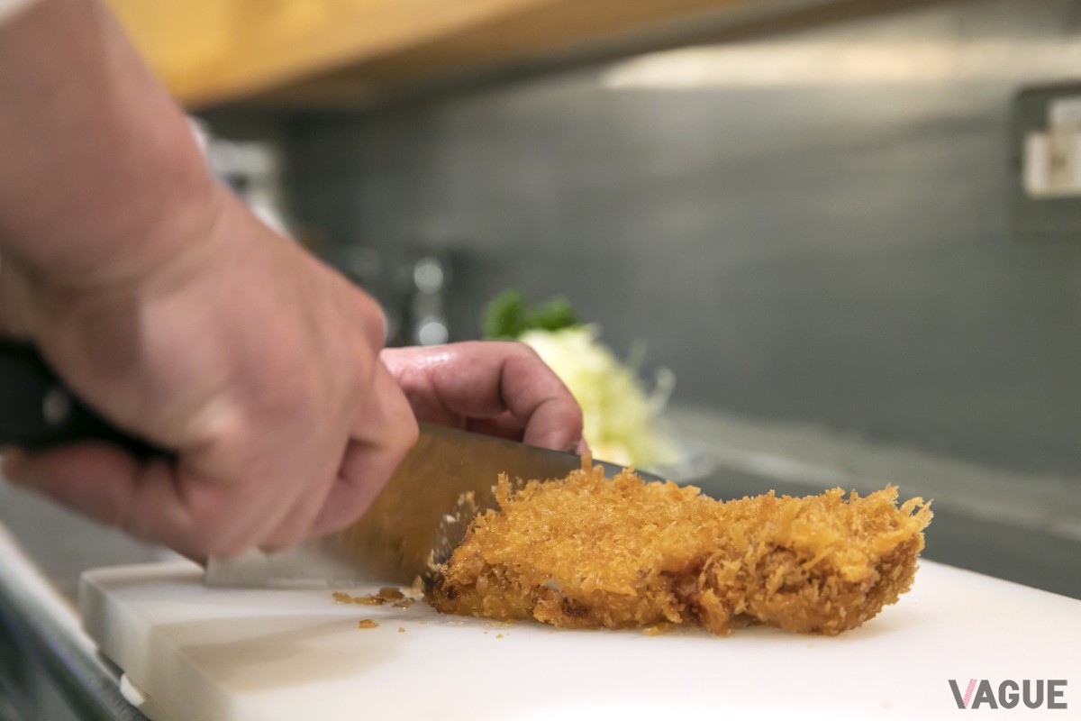 揚げたてのロースカツをカットしていく。衣が立っているのがわかる