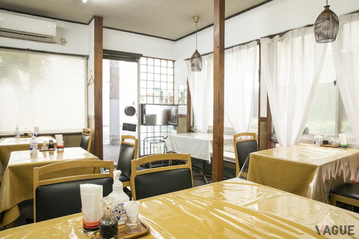 テーブル席の店内。奥に階段があり、2階の個室席へ上がっていく