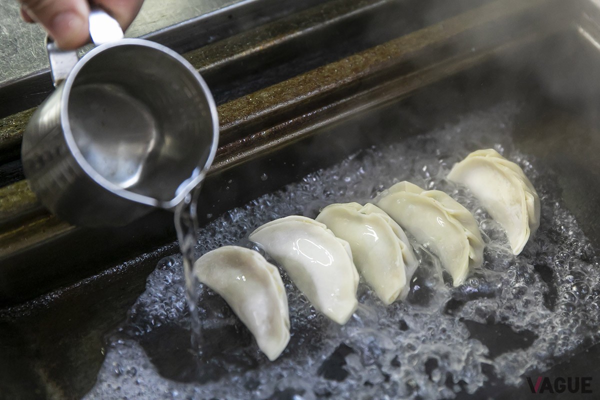 鉄板に乗せた餃子の周りに水をかけ蒸していく。一気に水が蒸発していく