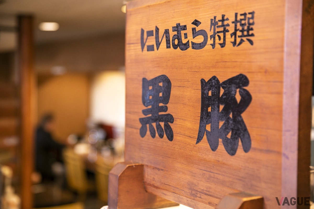 店に昔から置かれている木の看板。「いつからあるのか、もうわからないほど前ですね」（武寛さん）