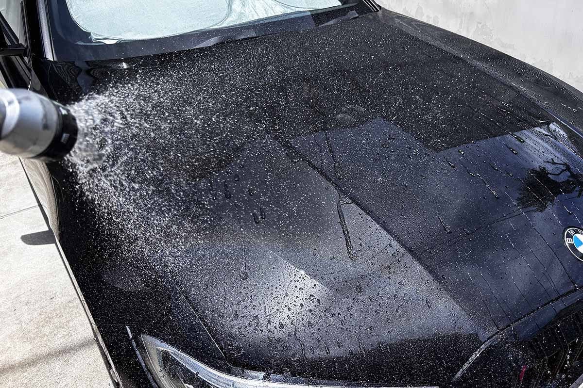 猛暑の昼間、黒いボディに水をかける洗車シーン。実はこれ、夏にもっとも避けたいNGタイミングかもしれません