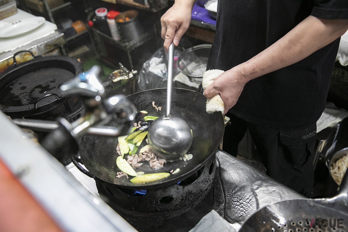 ナスやピーマン、豚肉、そしてスライスしたニンニクを強火で一気に炒めていく