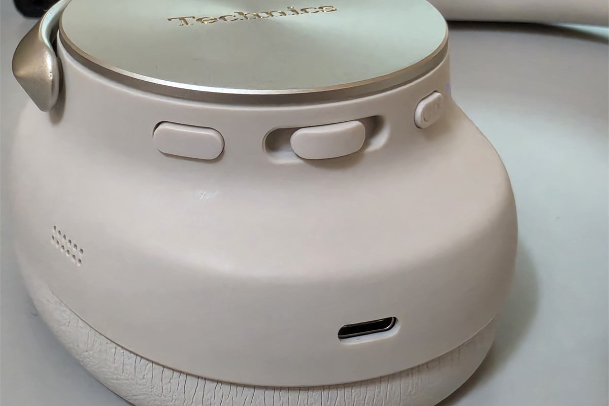 ハウジングに配置された操作ボタンとUSB Type-C端子。金属パーツや曲面を生かした外観の中に、操作と接続のための要素が収まっている。音の良さだけでなく、日常で手に触れる部分まで含めて製品を見られるディテールだ。