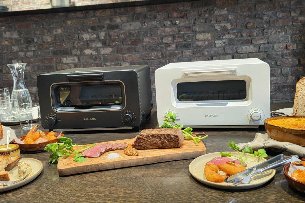 会場に並んだ新しい「BALMUDA The Toaster」。見慣れた外観のそばには、パンだけでなく肉料理や揚げ物も並びます。今回の進化は、朝のトーストから食事の仕上げまで、使う場面を広げたことにも表れています。