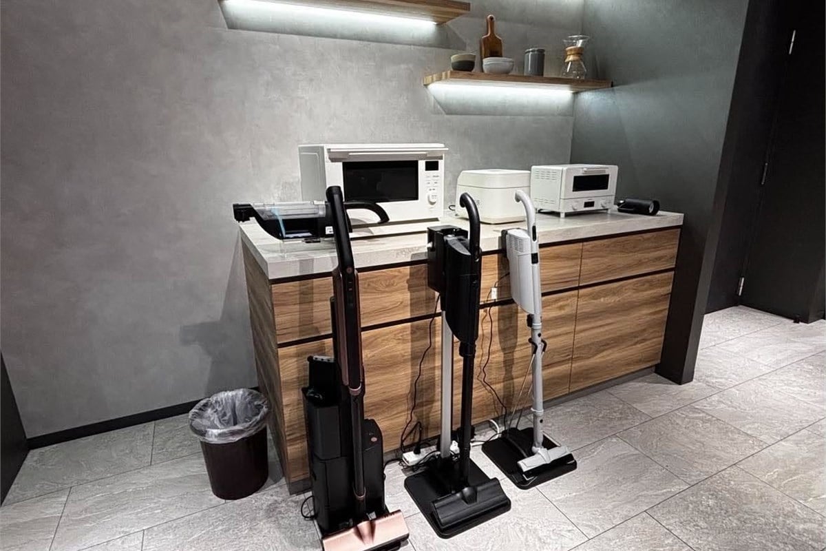 会場に展示された複数タイプのコードレス掃除機。自動ゴミ収集、サイクロン、紙パックなど方式を一つに絞らず、ゴミ捨てや手入れに対するユーザーそれぞれの考え方に合わせて選べるラインアップを構成する。