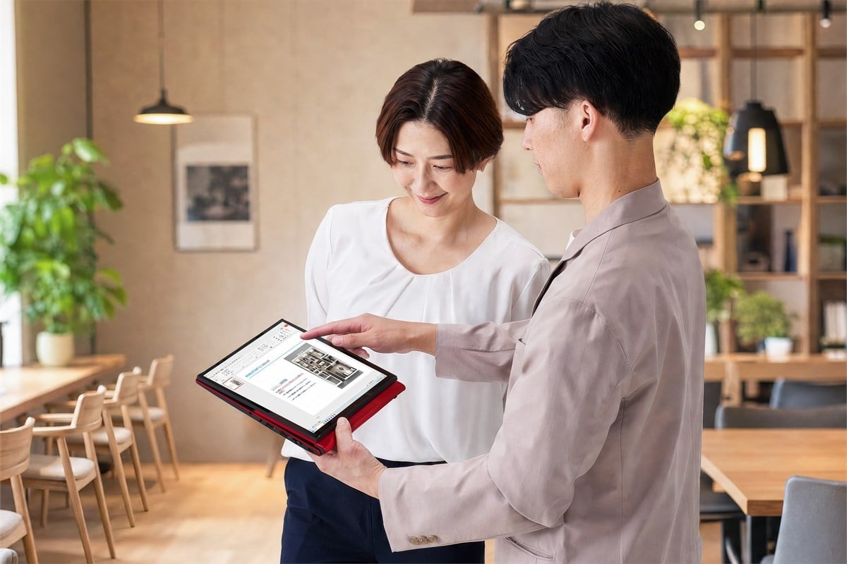 タブレットモードにしたVAIO Tの画面を、立った相手へ見せる使用イメージ。PCを持ち上げたり向きを変えたりせず、画面だけを動かして情報を共有できることが、マルチフリップの実用的な価値です。