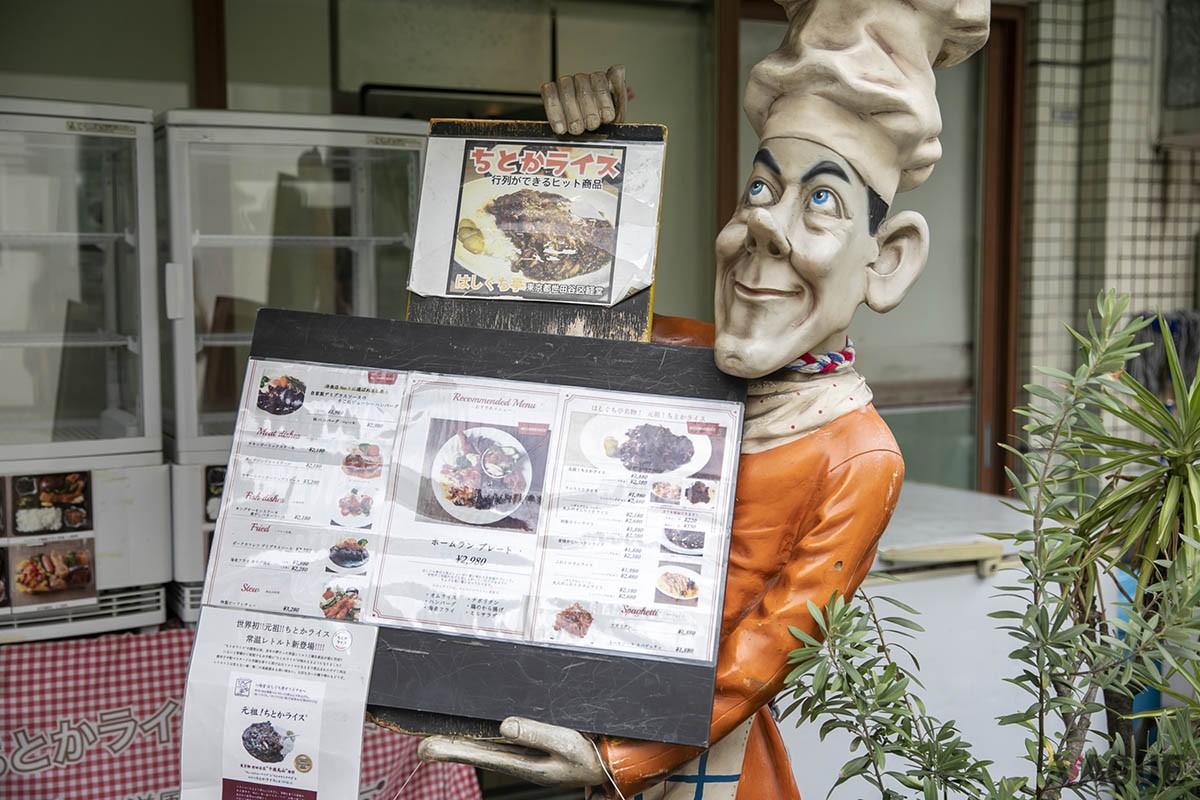 店頭に置かれた大きな人形。ふらっと訪れた人がメニューを除く姿も