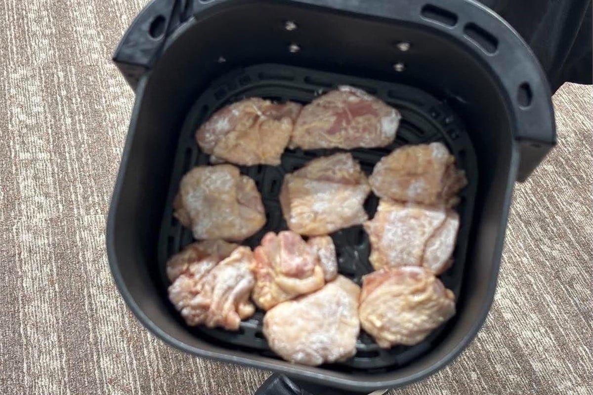 加熱前の鶏肉をバスケットに並べた状態。衣を付けた肉を置く際は、食材同士が重なりすぎないようにし、熱風の通り道を確保することが大切だ。見た目は小さな工夫でも、熱風循環式の調理家電では仕上がりに関わるポイントになる。