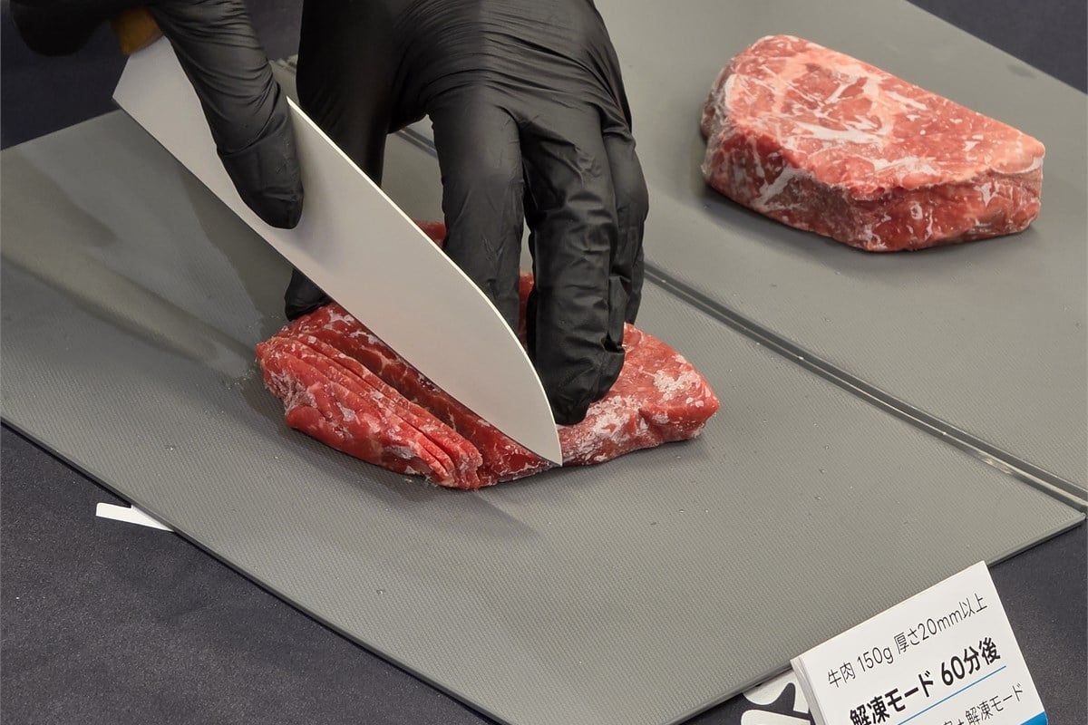 冷凍した肉を包丁で切る、セレクトチルド室の解凍モード実演。約60分で調理しやすい状態を目指し、その後は微氷結保存へ自動移行するという。時間に合わせて食材を取り出す負担を減らす狙いがある。