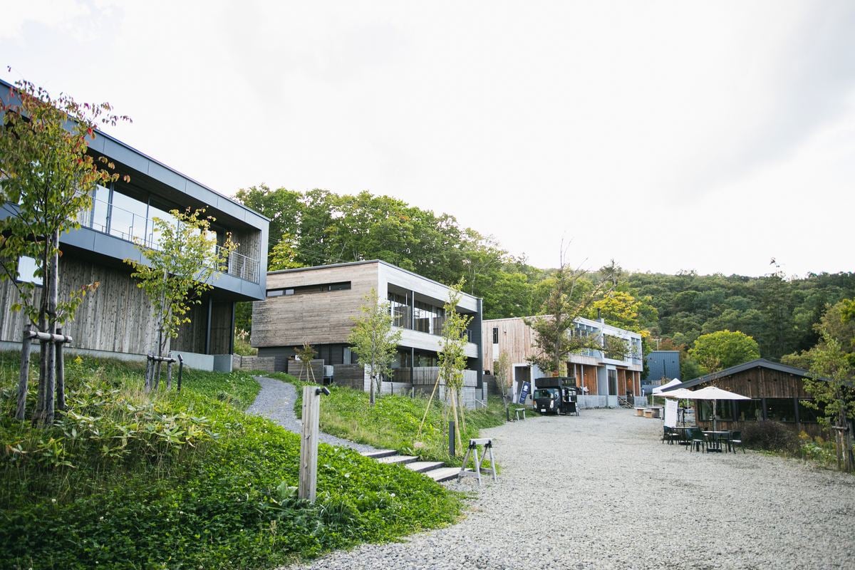 緑の斜面に建物が並び、泊まる楽しみが敷地へ広がる