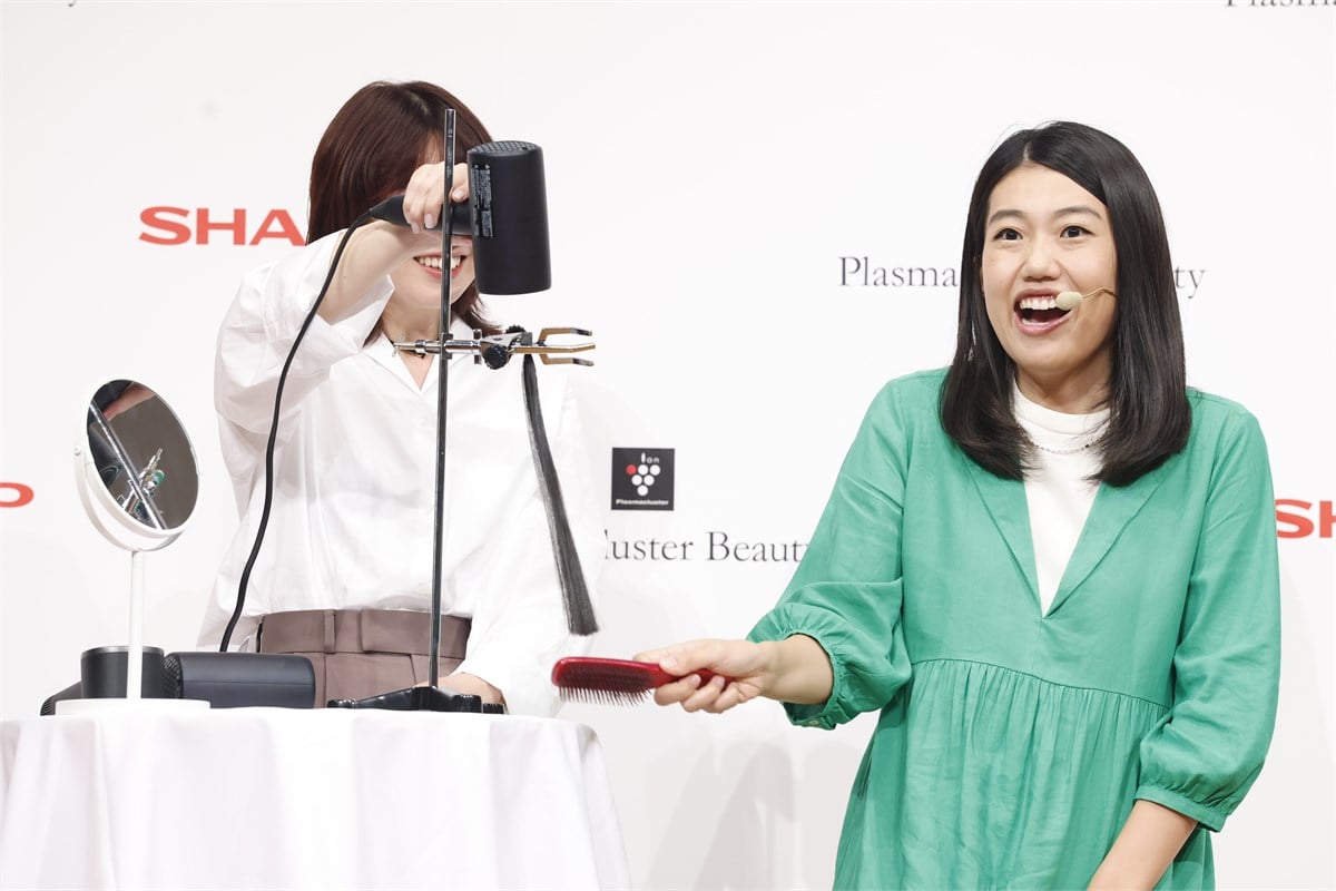 毛束とドライヤーを使い、髪のまとまり方を比較した発表会の実演。温風を当てるだけの機器と思われがちなドライヤーですが、シャープは静電気を抑えるプラズマクラスターの働きもヘアケアの価値として打ち出しました。実演はその違いを生活者に伝えるための工夫です。