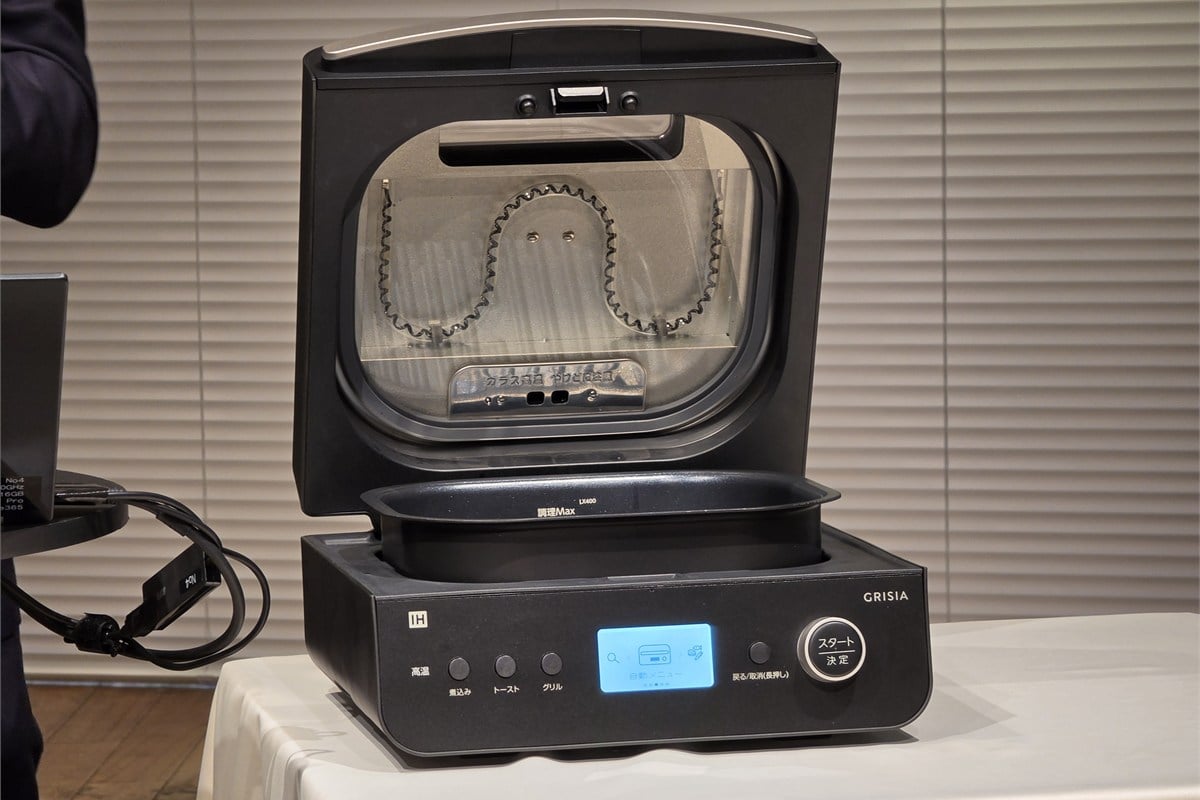 ふたを開けたGRISIAの実機。上側には二往復カーボンヒーターがガラス越しに見え、下側にはインナーポット、底面にはIHヒーターが収まる。上下から食材を加熱する構造が、肉や魚をひっくり返す手間を減らす仕組みの中心だ。