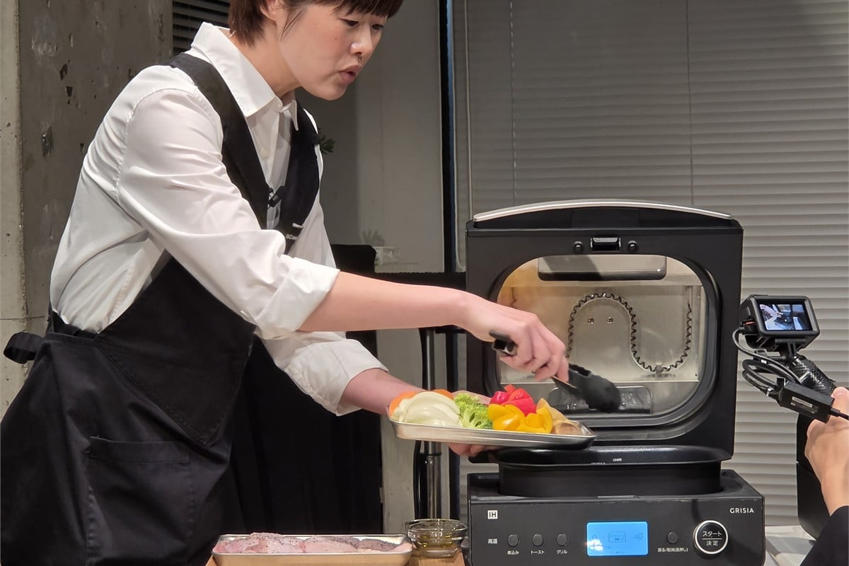 ABC Cooking Studioの澤田智子氏が、チキンと野菜のぎゅうぎゅう焼きの材料をインナーポットに並べる実演。彩りのある野菜を先に入れ、鶏肉を皮目を上にして重ねることで、調理と盛り付けを一度に進める使い方を紹介した。