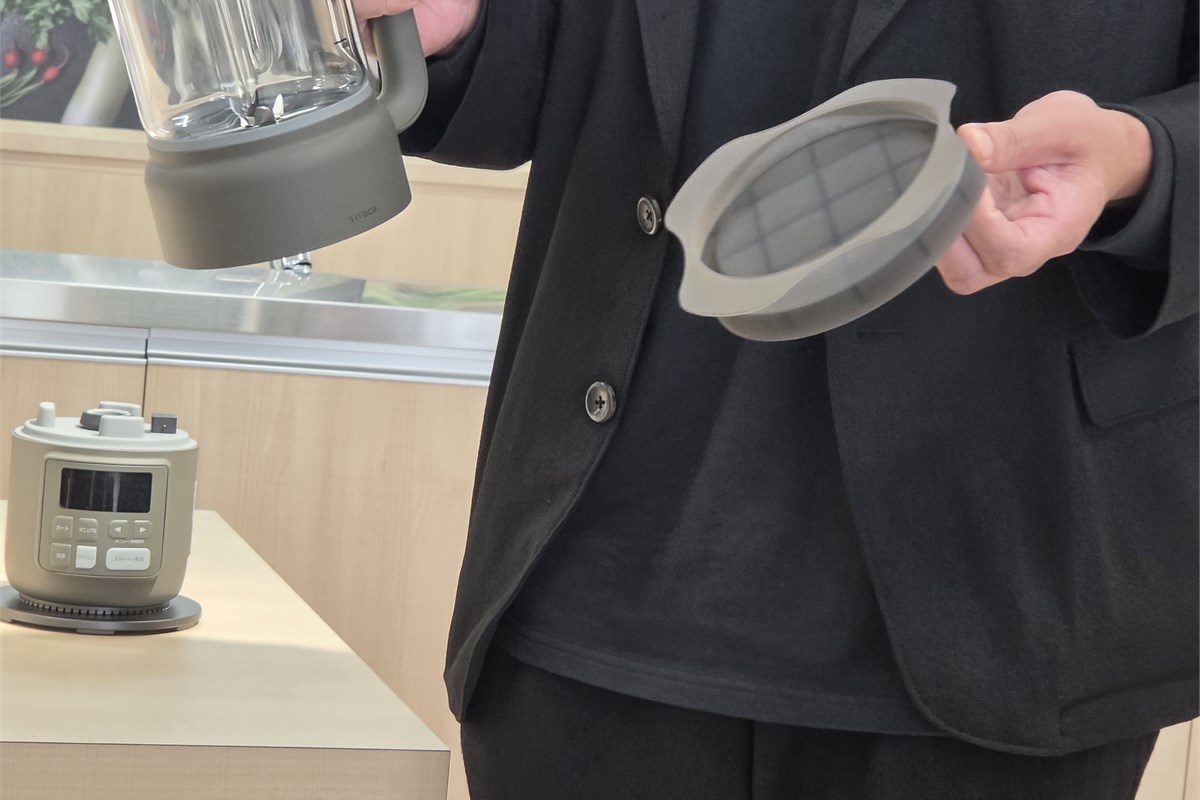新たに付属するポット底面用のシリコンカバーを紹介する場面。底面に電気部品を備えるため、洗浄時の水はねを気にする声に応えた。カバーを装着しても、ポットを水に浸して丸洗いできるわけではない。