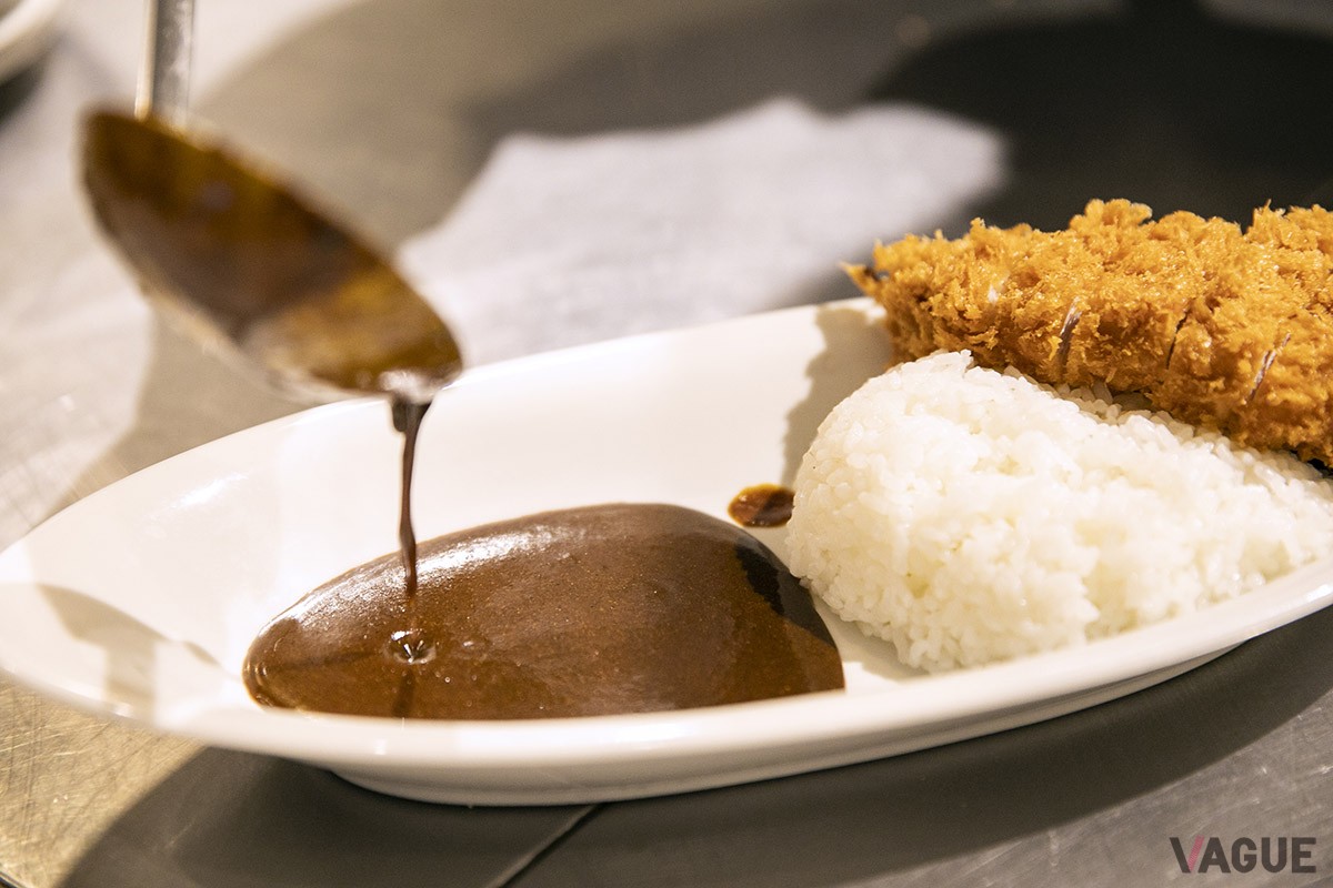 トンカツを揚げ、ゴハンを器によそったら、最後にカレーをかけて完成