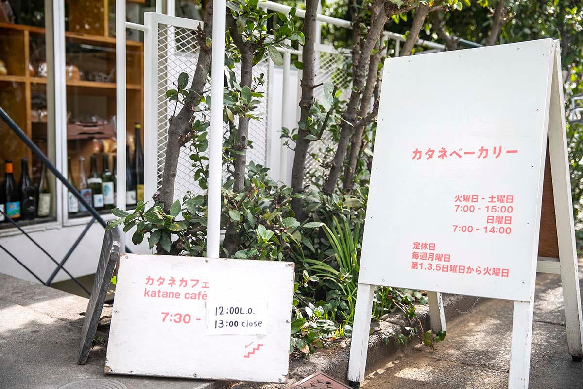 店頭に置かれた看板。階段を降りるとカフェに。看板の営業案内は取材時のもの