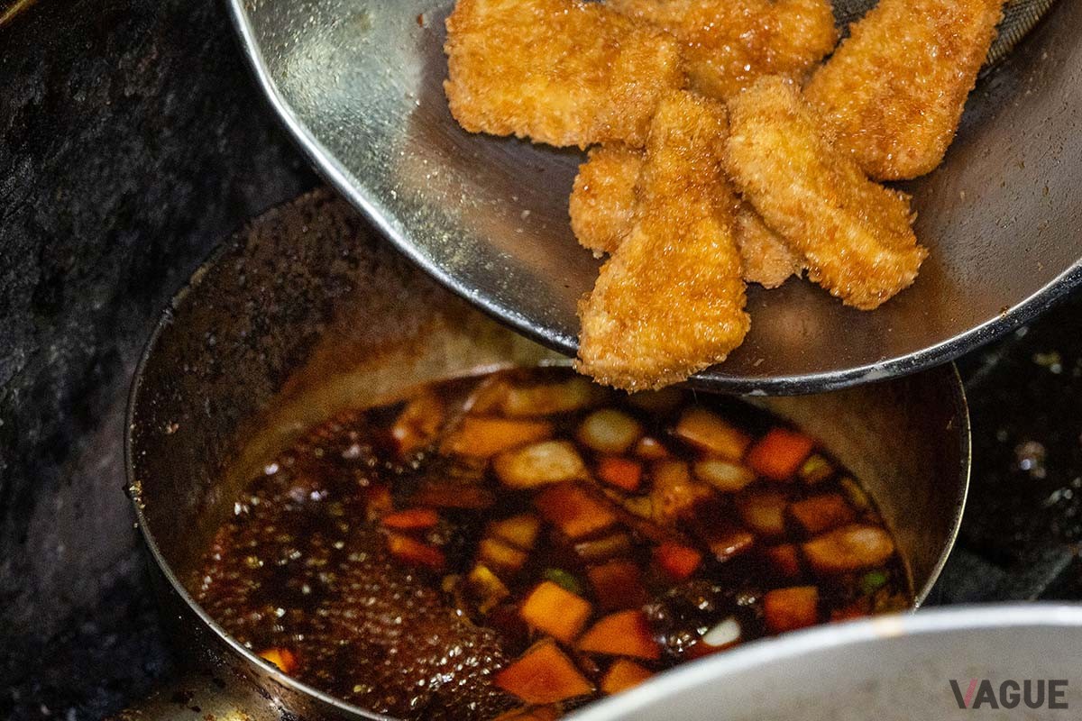 野菜の入ったタレの中に一口サイズのカツを入れてしっかり絡ませる