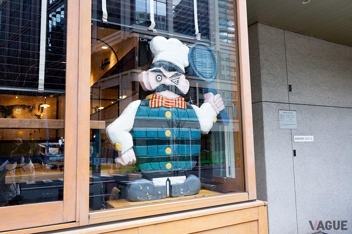窓の片隅には、昔から店を見守る木彫りのコックさんのオブジェが