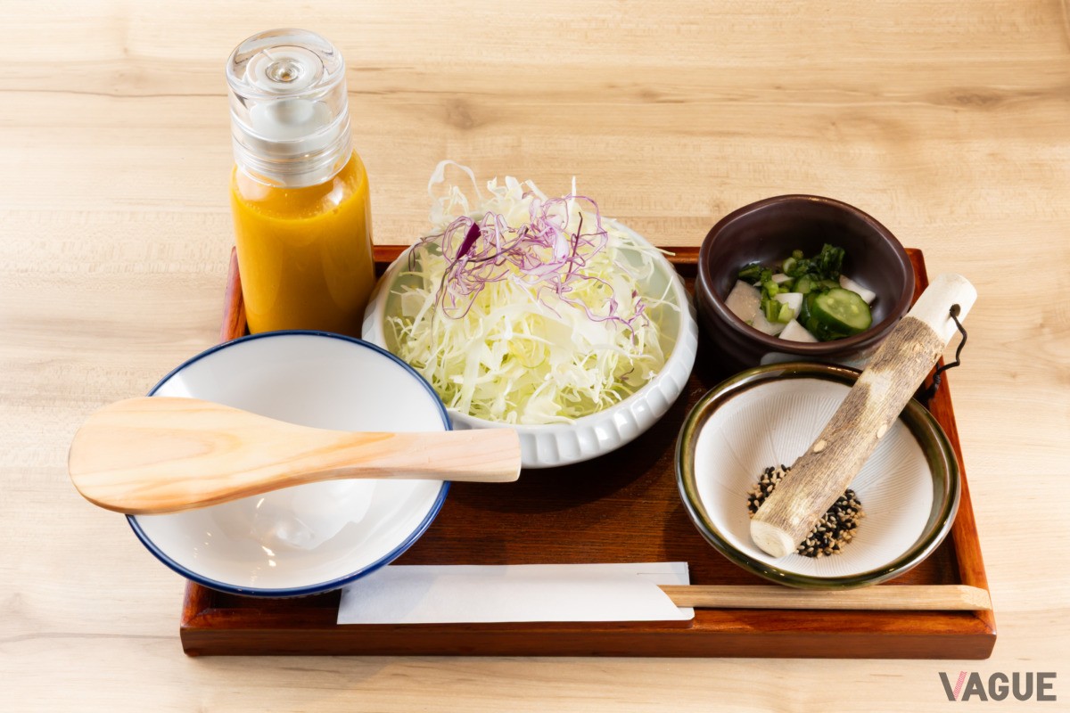 最初に千切りキャベツ、浅漬け、タレを入れるためのゴマ入りの器、お茶碗などが出される。黄色いボトルはキャベツ用ドレッシング