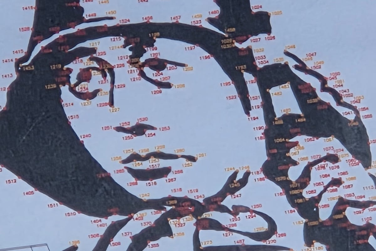 グラフィティを壁面に忠実に描くため、元となるグラフィティにポイントごとに数字を打ち、測量チームが実際の堤体壁面に同じようにガイドとなるポイントを打っていくという