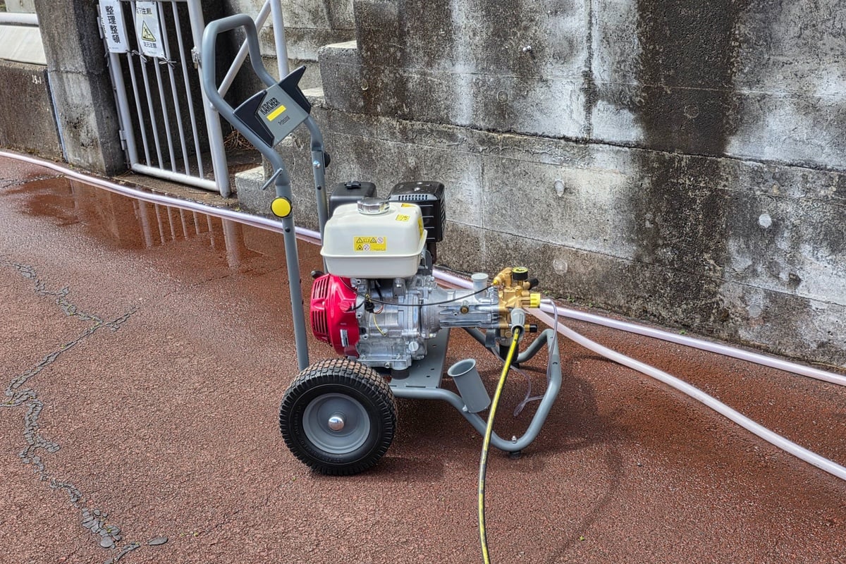 今回洗浄に使われていたのが、エンジンタイプのケルヒャーの業務用冷水高圧洗浄機。重機や資材にこびりついた頑固な汚れもパワフルに洗浄するハイパワー仕様。電源のない場所でも作業が可能です。優れた耐久性でハードな現場にも対応する。丈夫なフレームと大型タイヤで移動も簡単だ