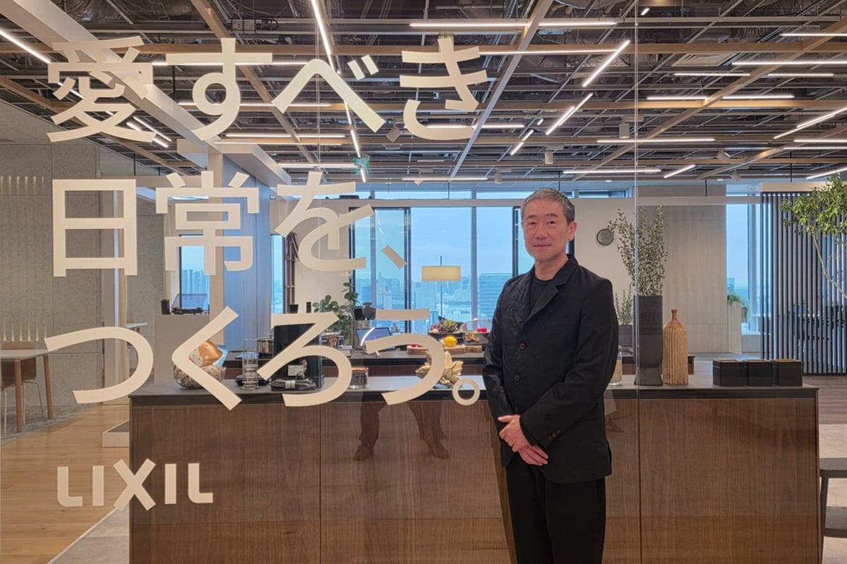 「愛すべき日常を、つくろう。」というメッセージの前に立つ羽賀氏。設備ではなく、暮らしの体験そのものをつくるというLIXILの新たな立ち位置が象徴されている