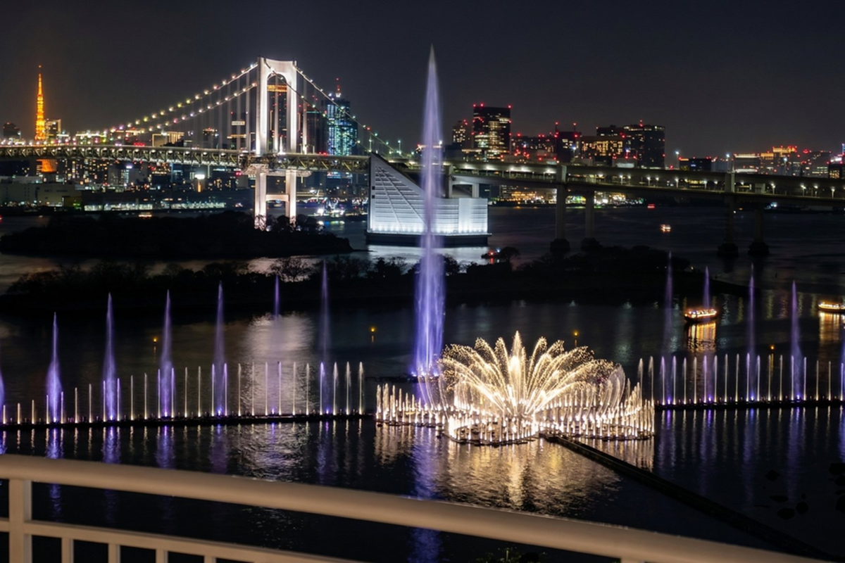 客室のバルコニーから望む「東京アクアシンフォニー」。レインボーブリッジや東京タワーを背景に、高さ約150メートルに達する大噴水など、光と水が織りなすダイナミックなショーが広がる