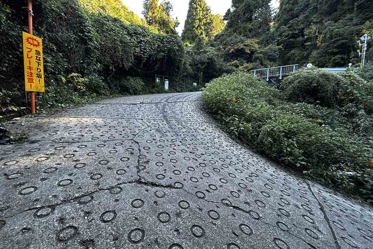 暗峠のもっとも急勾配地点がココ。タイヤのスリップ痕が無数にある。iPhoneで角度を調べてみたところ、22度を指した