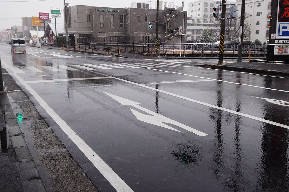 雨天時の道路にはマンホールのふたや白線といった滑りやすい要因が数多く存在